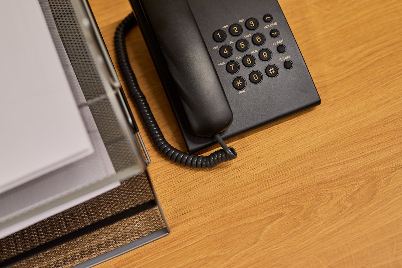 services-img A tidy office desk featuring a classic black telephone and organized documents.